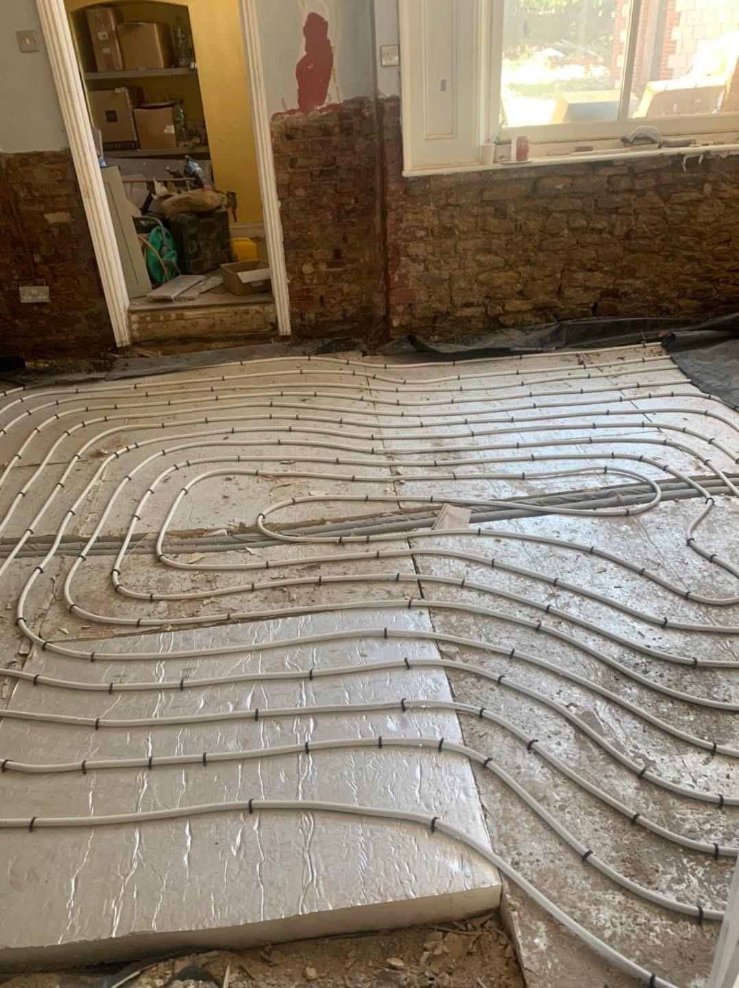 Underfloor heating loops laid across insulation panels