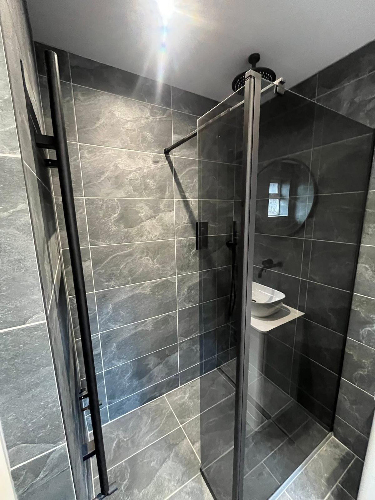Walk-in shower with matt black fittings and slate tiles