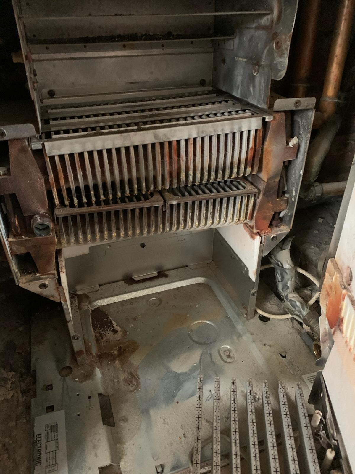 Sludge-damaged boiler heat exchanger removed during fault finding